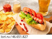 Вкусный хот-дог, чипсы и пиво на столе. Стоковое фото, фотограф Pixel_shot / Фотобанк Лори