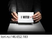 Голосование женщины возле урны на темном фоне, крупным планом. Стоковое фото, фотограф Pixel_shot / Фотобанк Лори