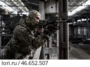 Боец в камуфляже на фоне промышленных конструкций. Спецназовец с автоматом в разрушенном цеху. Вооружённый солдат в индустриальном пространстве. (2020 год). Редакционное фото, фотограф Евгений Зимин / Фотобанк Лори