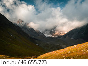 Вершины гор в облаках на закате в горном ущелье. Стоковое фото, фотограф Сармат Батагов / Фотобанк Лори