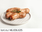 Тарелка с вкусными жареными колбасками на столе. Стоковое фото, фотограф Pixel_shot / Фотобанк Лори