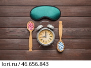 Маска для сна, будильник и таблетки на деревянном фоне. Стоковое фото, фотограф Pixel_shot / Фотобанк Лори