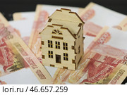 Банкноты номиналом 5000 российских рублей и деревянный домик. Стоковое фото, фотограф Алексей Белкин/NEWS.ru / ТАСС / Фотобанк Лори