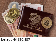 Удостоверение сотрудника Федеральной налоговой службы России, физические монеты криптовалют и банкноты номиналом 5000 российских рублей. Стоковое фото, фотограф Сергей Елагин/Бизнес Online / ТАСС / Фотобанк Лори