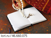 Мусульманский молитвенный коврик, бусы и Коран на фоне гранж. Стоковое фото, фотограф Pixel_shot / Фотобанк Лори
