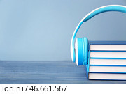 Книги и современные наушники на столе. Концепция аудиокниги. Стоковое фото, фотограф Pixel_shot / Фотобанк Лори