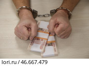Наручники на арестованном преступнике и деньги. А. Стоковое фото, фотограф Белкин/Бизнес Online / ТАСС / Фотобанк Лори