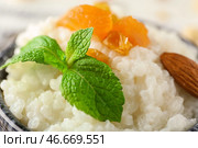 Вкусный рисовый пудинг с сухофруктами и миндалем в миске, крупным планом. Стоковое фото, фотограф Pixel_shot / Фотобанк Лори