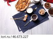 Джезве из горячего шоколада с молоком и сладостями на белом деревянном столе. Стоковое фото, фотограф Pixel_shot / Фотобанк Лори