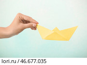 Женщина держит оригами лодка на цветном фоне. Стоковое фото, фотограф Pixel_shot / Фотобанк Лори