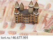 Игрушечный деревянный домик и банкноты номиналом 5000 российских рублей. А. Стоковое фото, фотограф Белкин/Бизнес Online / ТАСС / Фотобанк Лори