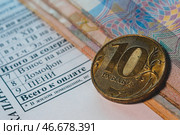 Монета и банкноты на квитанции для оплаты коммунальных услуг. С. Стоковое фото, фотограф Елагин/Бизнес Online / ТАСС / Фотобанк Лори