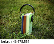 Современные наушники и книги на зеленой траве. Концепция аудиокниги. Стоковое фото, фотограф Pixel_shot / Фотобанк Лори