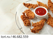 Охлаждающая подставка со вкусными наггетсами и томатным соусом на светлом столе. Стоковое фото, фотограф Pixel_shot / Фотобанк Лори