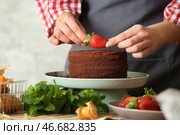 Женский кондитер украшать вкусный шоколадный торт на столе, крупным планом. Стоковое фото, фотограф Pixel_shot / Фотобанк Лори