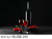 Очки и бутылка со сладким вишневым ликером на черном фоне. Стоковое фото, фотограф Pixel_shot / Фотобанк Лори
