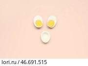 Половинки вкусных отваренных яиц на розовом фоне. Стоковое фото, фотограф Pixel_shot / Фотобанк Лори
