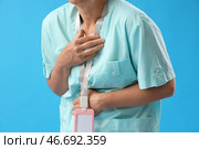 Женщина-врач переносит сердечный приступ на фоне синего цвета, крупный план. Стоковое фото, фотограф Pixel_shot / Фотобанк Лори