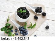 Чашка с свежей ежевикой и голубикой на светлом деревянном фоне, крупным планом. Стоковое фото, фотограф Pixel_shot / Фотобанк Лори