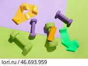 Композиция с бутылкой крема для солнцезащиты, гантелями и эластичными лентами на цветном фоне. Стоковое фото, фотограф Pixel_shot / Фотобанк Лори