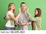 Женские студентки с мелками и их одноклассница на зеленом фоне. Стоковое фото, фотограф Pixel_shot / Фотобанк Лори