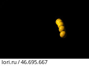 Стробоскопическое фото желтых движущихся шаров на черном фоне. Стоковое фото, фотограф Pixel_shot / Фотобанк Лори