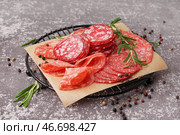 Сетка с ломтями вкусной салями на сером фоне. Стоковое фото, фотограф Pixel_shot / Фотобанк Лори