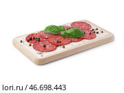 Деревянная доска с ломтями вкусной салями, изолированная на белом фоне. Стоковое фото, фотограф Pixel_shot / Фотобанк Лори