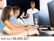 Adult man speaker stands in front of students and talks about use of artificial intelligence. Стоковое фото, фотограф Яков Филимонов / Фотобанк Лори
