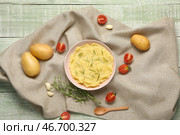 Миска вкусного картофельного пюре с розмарином, помидорами и чесноком на зеленом деревянном фоне. Стоковое фото, фотограф Pixel_shot / Фотобанк Лори