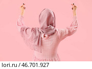 Прекрасная молодая мусульманка делает сердце пальцами на розовом фоне, вид сзади. Стоковое фото, фотограф Pixel_shot / Фотобанк Лори