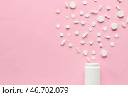 Разные таблетки высыпаются из бутылки на розовом фоне. Стоковое фото, фотограф Pixel_shot / Фотобанк Лори