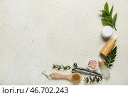 Бутылки косметического масла с растительными веточками и массажером на белом гранжевом фоне. Стоковое фото, фотограф Pixel_shot / Фотобанк Лори