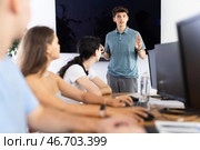 Young guy speaker stands in front of students and talks about use of artificial intelligence. Стоковое фото, фотограф Яков Филимонов / Фотобанк Лори
