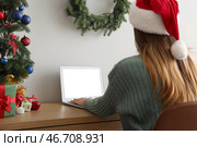 Женщина работает с ноутбуком за столом в офисе накануне Рождества. Стоковое фото, фотограф Pixel_shot / Фотобанк Лори