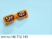Слово SPF и цифры, написанные солнцезащитным кремом на стильных солнцезащитных очках на цветном фоне. Стоковое фото, фотограф Pixel_shot / Фотобанк Лори
