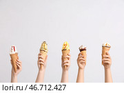 Женские руки с различным сладким мороженым в вафельных рожках на сером фоне. Стоковое фото, фотограф Pixel_shot / Фотобанк Лори