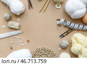 Рамка из клубков пряжи и аксессуаров для вязания на бежевом фоне. Стоковое фото, фотограф Pixel_shot / Фотобанк Лори
