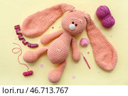 Вязаная крючком игрушка-кролик, клубок пряжи и измерительная лента на желтом фоне. Стоковое фото, фотограф Pixel_shot / Фотобанк Лори