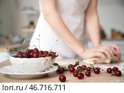 Чаша с вишней и женщина месит тесто на кухне, крупный план. Стоковое фото, фотограф Pixel_shot / Фотобанк Лори
