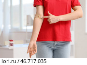 Женщина-донор крови указывает на наложенный пластырь в клинике, крупным планом. Стоковое фото, фотограф Pixel_shot / Фотобанк Лори