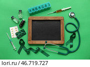 Пустая школьная доска, зелёные ленты и медицинские принадлежности на цветном фоне. Национальный месяц осведомлённости о церебральном параличе. Стоковое фото, фотограф Pixel_shot / Фотобанк Лори
