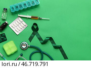 Атласная зелёная лента, шкатулка для таблеток и медицинские принадлежности на цветном фоне, крупный план. Стоковое фото, фотограф Pixel_shot / Фотобанк Лори