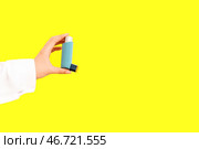 Женские докторские руки с ингалятором на желтом фоне. Стоковое фото, фотограф Pixel_shot / Фотобанк Лори