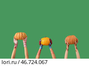 Руки зомби с спелыми тыквами на зеленом фоне. Празднование Хэллоуина. Стоковое фото, фотограф Pixel_shot / Фотобанк Лори