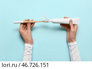 Женские руки с зубной пастой, щеткой и пластиком на синем фоне. Месяц осведомленности о микропластике. Стоковое фото, фотограф Pixel_shot / Фотобанк Лори