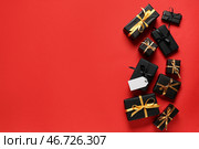 Подарочные коробки с пустыми бумажными ярлыками на красном фоне. Распродажа в Черную пятницу. Стоковое фото, фотограф Pixel_shot / Фотобанк Лори
