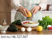 Женщина натирает лимонную цедру на пасту за столом на кухне, крупный план. Стоковое фото, фотограф Pixel_shot / Фотобанк Лори