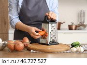 Женщина натирает морковь на терке за столом на кухне, крупный план. Стоковое фото, фотограф Pixel_shot / Фотобанк Лори