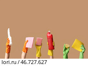Женские руки держат бутылки с моющими средствами, тряпки, губку и лимон на коричневом фоне. Стоковое фото, фотограф Pixel_shot / Фотобанк Лори